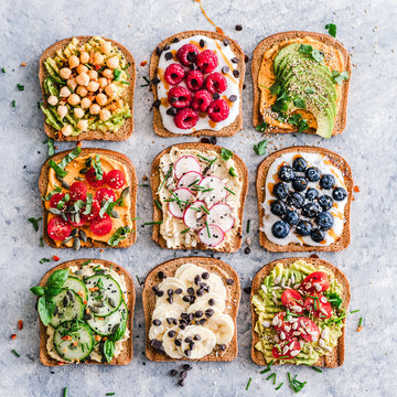 Variety of toasts with fruit and vegetables on table