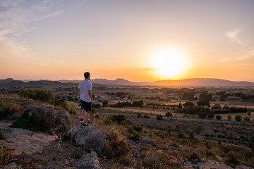 Fototapeta premium Man watching the sunset in a mountain