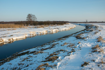 River and snow in the meadows