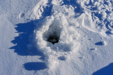 Fototapeta na wymiar ice hole for fishing on a sunny day