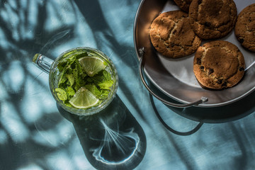 Lemonade with lime and mint and cookies on a tin tray flat layout