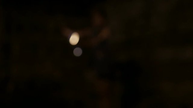 Female artist performing dance fire show at night - blurry defocused bokeh footage