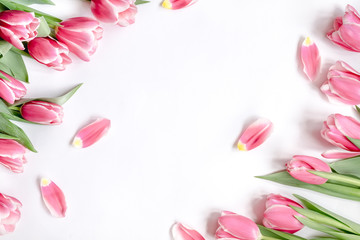The composition of flowers. Frame made of pink tulips flowers on a white background. Flat lay, top view, copy space