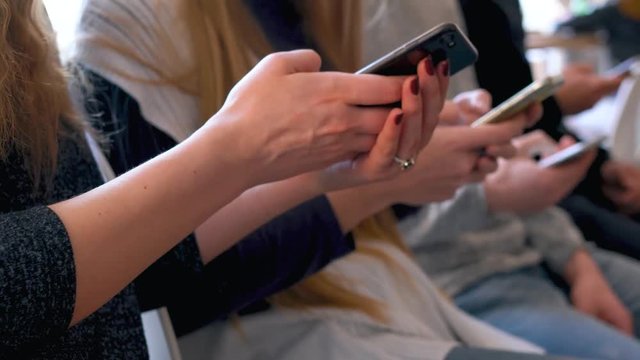 Group of people use mobile phones in a cafe instead of communicating with each other