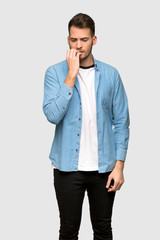 Handsome man having doubts over grey background