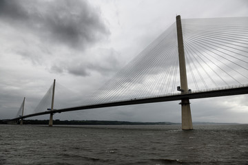 Modern Queensferry Crossing cable stayed suspension bridge over the Firth of Fourth to Edinburgh Scotland UK under stormy gray sky