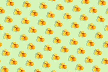 Oranges on bright colored yellow background. Repeating pattern, preparation for wallpaper citrus mood.