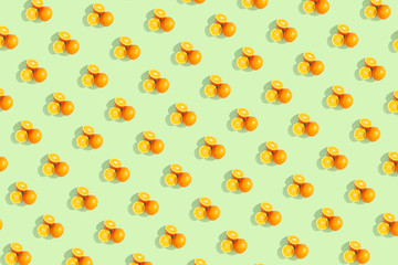 Oranges on bright colored yellow background. Repeating pattern, preparation for wallpaper citrus mood.