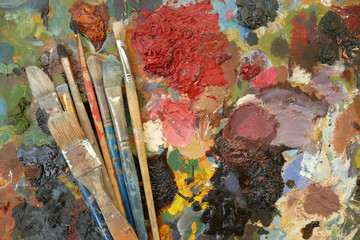 old art brushes on a palette with paints. top view. copy space