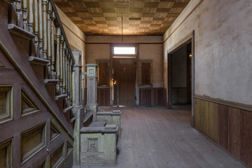 Parquet ceiling and vintage wooden staircase with large entry way in a beautiful abandoned plantation home