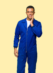 Young afro american worker man with toothache on isolated background