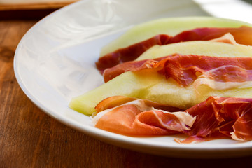  traditional Italian appetizer of prosciutto and melon. selective focus and copy space