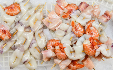 fresh peeled seafood shrimp and squid with pieces of salmon in the ice, Italian market, Italian cuisine. selective focus