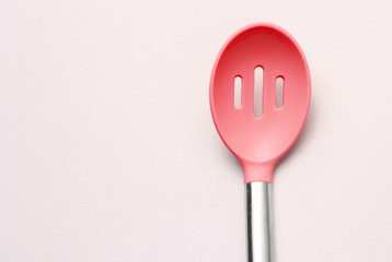 Siliconered  ladle for cooking with metal handle on a gray background. Top view..