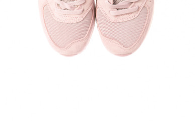 Fragment of coral color sports sneaker isolated on white background. Copy space.