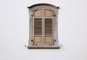 Obraz premium arched window with wooden shutters on a white wall