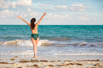 Fototapeta na wymiar Carefree and happy young brunette woman on the beach in the Mayan Riviera, Mexico.