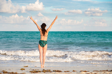 Carefree and happy young brunette woman on the beach in the Mayan Riviera, Mexico.