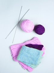 Knitting needles, thread balls, yarn on a gray background..