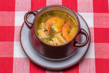 Seafood background. Macro of freshly cooked Mediterranean fish soup with salmon and shrimps in a...