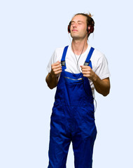 Workman listening to music with headphones and dancing on isolated background