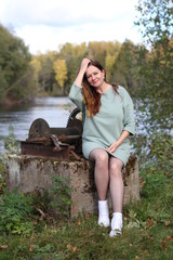 A woman sitting near a river
