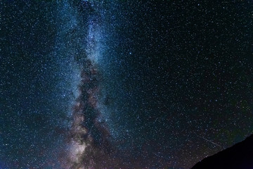 A bright starry night with millions of stars and a galaxy Milky way from the altitude of the mountain ranges.