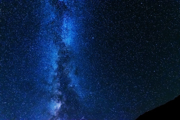 A bright starry night with millions of stars and a galaxy Milky way from the altitude of the mountain ranges.