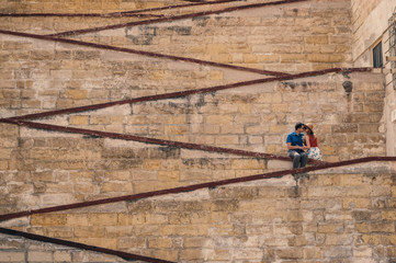 Obraz na płótnie Canvas Man kissing woman on the city walls
