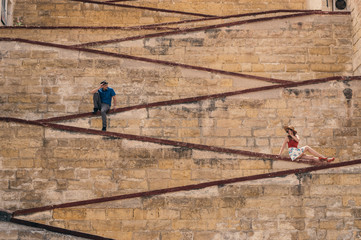 Man and woman sitting on the city walls