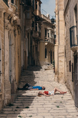 Man and woman laying on the stairs on the street