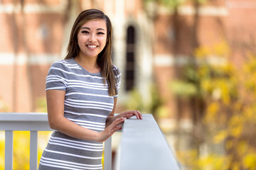 Portrait of a Chinese American female youth outdoors, having fun smiling