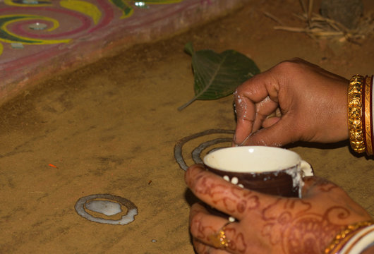 Alpana (White Paint With Liquid Rice-Paste) is being painted in a Bengali wedding ceremony at the rural Bengal.