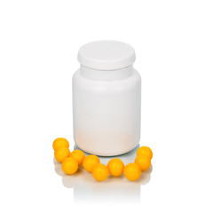 Yellow pills near bottle isolated on the white background