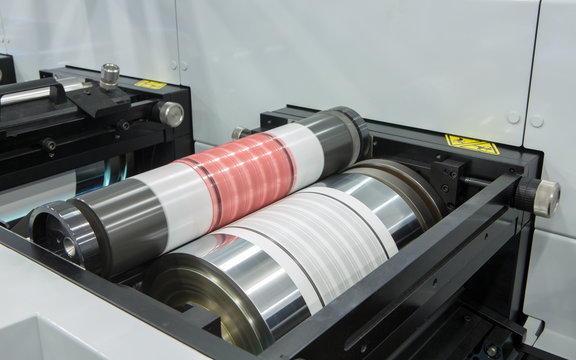 Flexography printing process on in-line press machine. Photopolymer plate stuck on printing cylinder, substrate is sandwiched between the plate and the impression cylinder to transfer the ink.