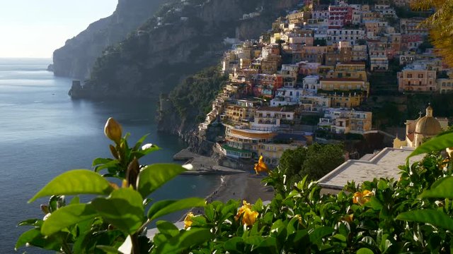 Colorful houses on a Tyrrhenian sea coast seen through green juicy flora in Positano, Italy. Positano is a village in Naples metropolitan area. UHD 4K