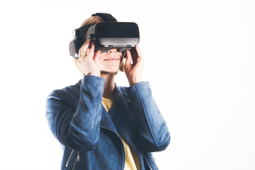 A young woman is wearing virtual reality glasses and reaching for something with his hands