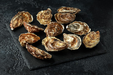 Fresh Oysters on rustic stone board. ready to open and eat