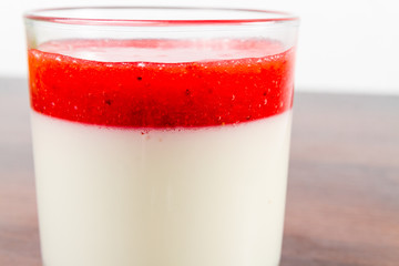 Strawberry panna cotta dessert in a glass isolated on a wood table recipe idea 