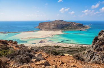 Scenery of sunny summer day with sand beach, turquoise sea and mountains. Blue horizon line. Place for tourists rest Balos lagoon, shore of Crete island, Greece. Ionian, Aegean and Libyan seas.
