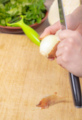 cook cleans the skin of an onion