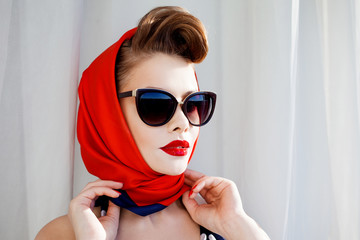 young beautiful woman with red lipstick and a headscarf.