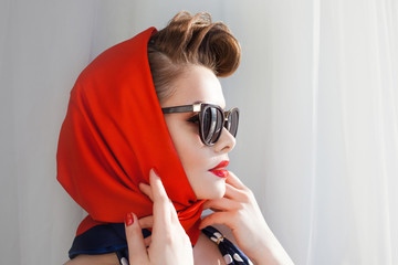 young beautiful woman with red lipstick and a headscarf.