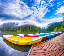 Boats on majestic mountain lake Lacul Rosu or Red Lake or Killer Lake