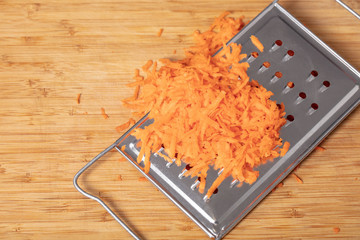 shredded carrots on a grater closeup