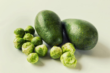 Avocado with brussel cabbages on white background.