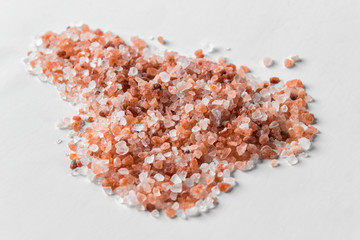 Fototapeta na wymiar Crystals of red himalayan salt on white backgound.