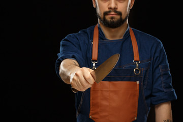 Man with black moustache showing metallic knife.