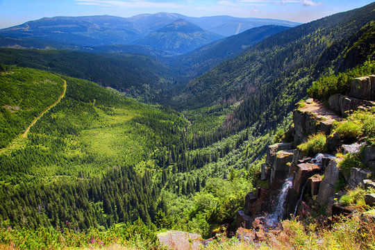 The highest waterfall in National park Giant mountains in Czech republic. Beutaiful view on landscape and on the big waterfall and the valley of river.