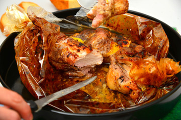 Roasted meat baked in the oven, knife and fork cutting roast.